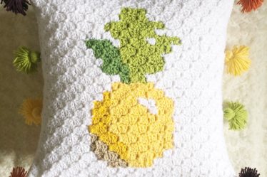 Corner to corner crochet pineapple pillow cover with multi-colored tassels